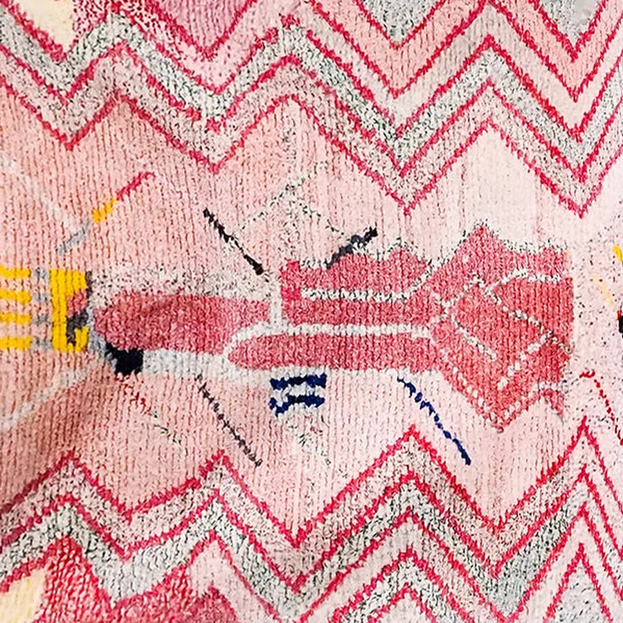 Gros plan sur le velours du tapis berbère coloré tiziri, rose et framboise