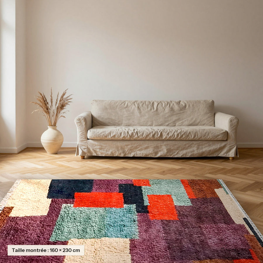 Tapis berbère coloré Tafsut, patchwork prune et orange posé dans un salon, taille 160 × 230 cm
