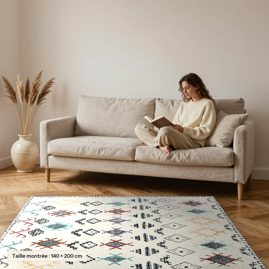 Tapis berbère coloré Taslint, losanges pastel posé devant un canapé, taille 140 × 200 cm