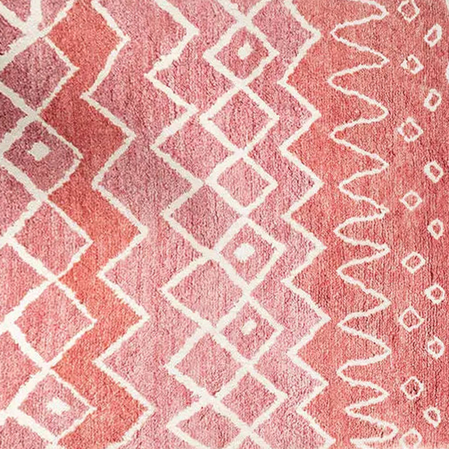 Gros plan sur le velours du tapis berbère coloré itri, rose terracotta