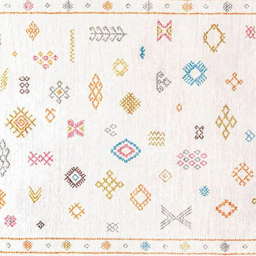 Gros plan sur le velours du tapis berbère coloré tamallat, écru à symboles colorés