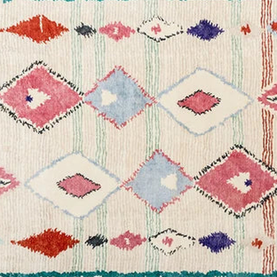Gros plan sur le velours du tapis berbère coloré taylalt, diamants corail et turquoise