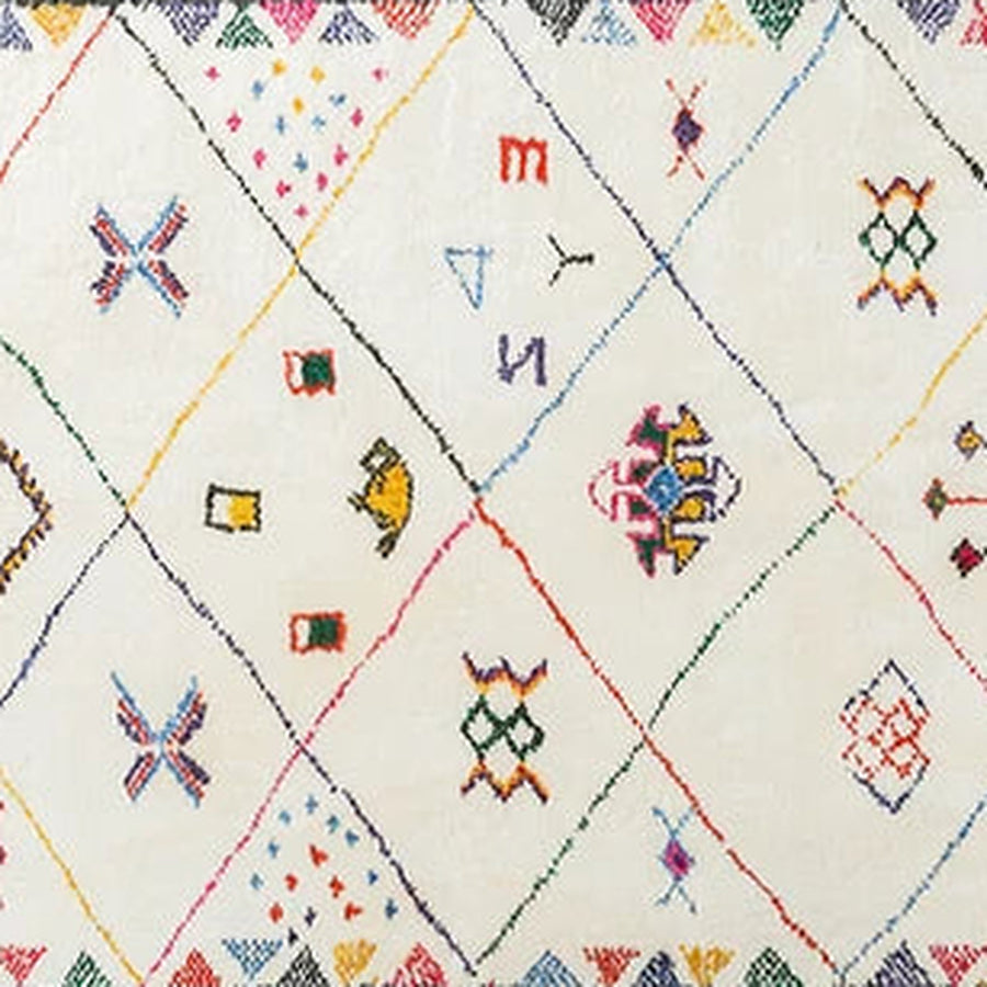 Gros plan sur le velours du tapis berbère coloré tanamart, grille de losanges colorés