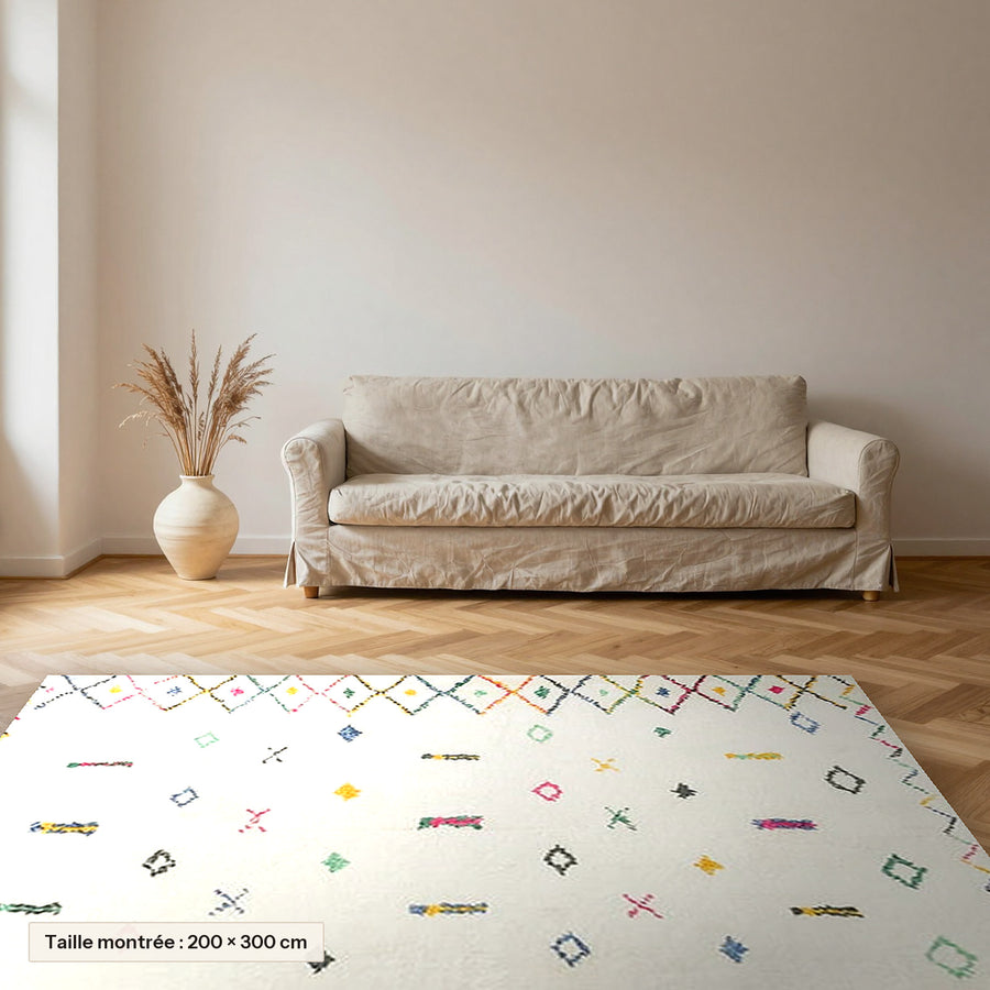 Tapis berbère coloré Tadmit, écru à touches colorées posé dans un salon, taille 200 × 300 cm
