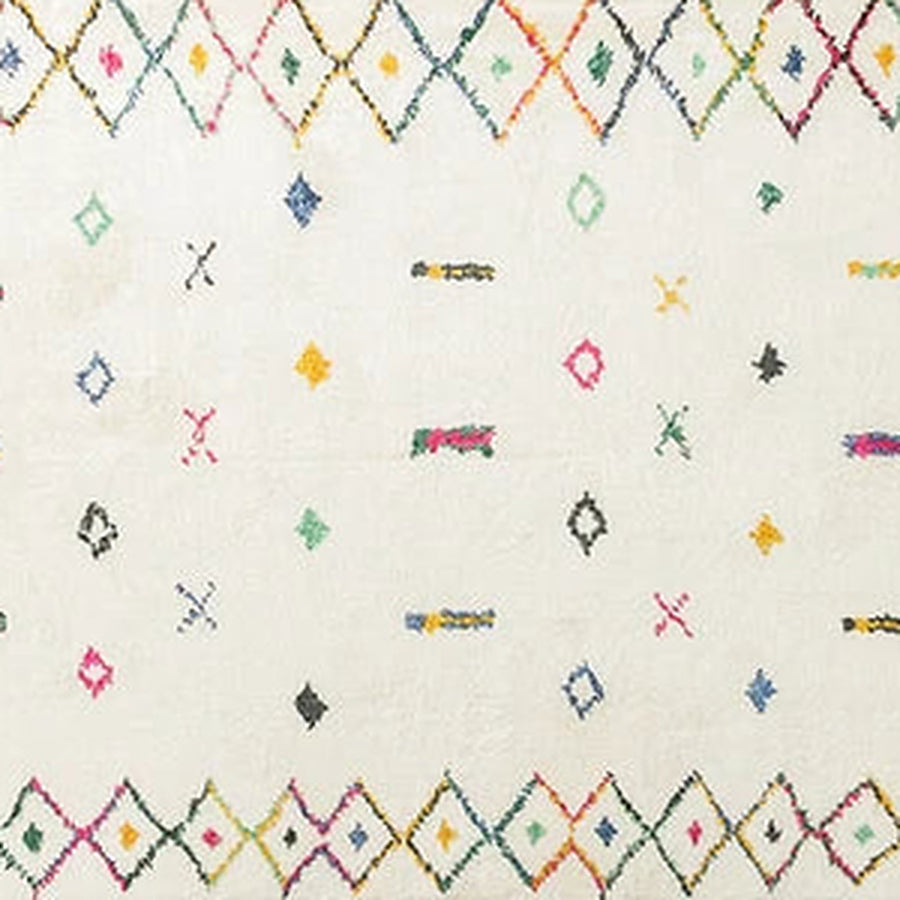 Gros plan sur le velours du tapis berbère coloré tadmit, écru à touches colorées