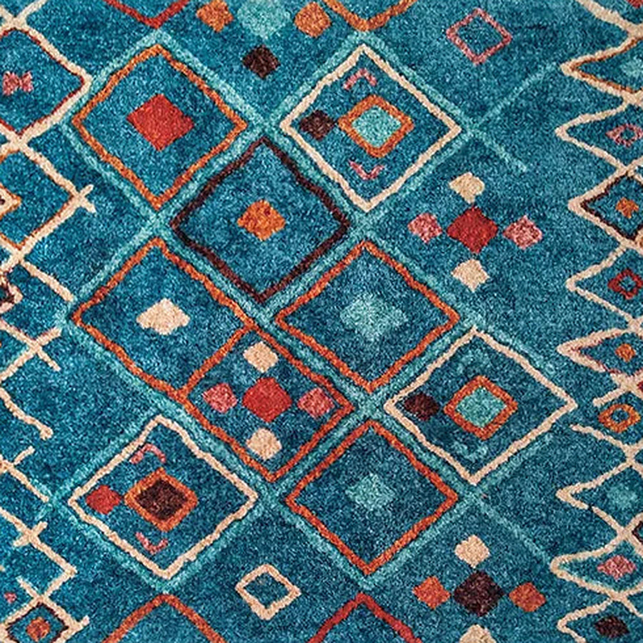 Gros plan sur le velours du tapis berbère coloré tawsimt, bleu canard à médaillons