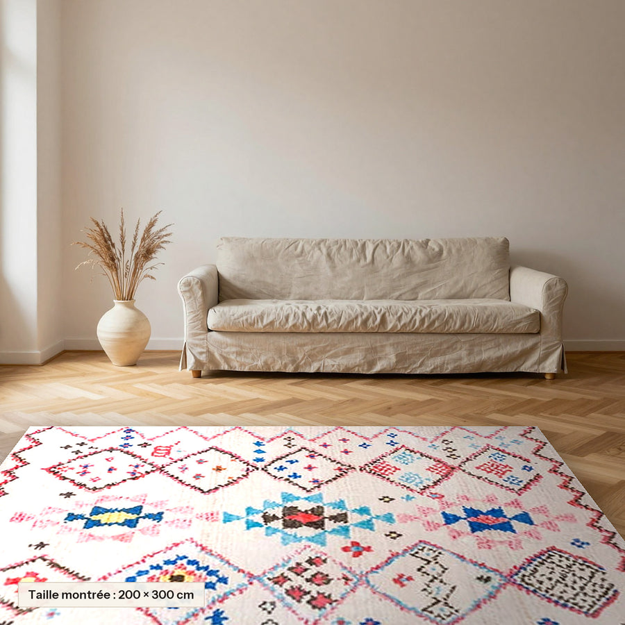Tapis berbère coloré Tamassant, losanges rose et turquoise posé dans un salon, taille 200 × 300 cm