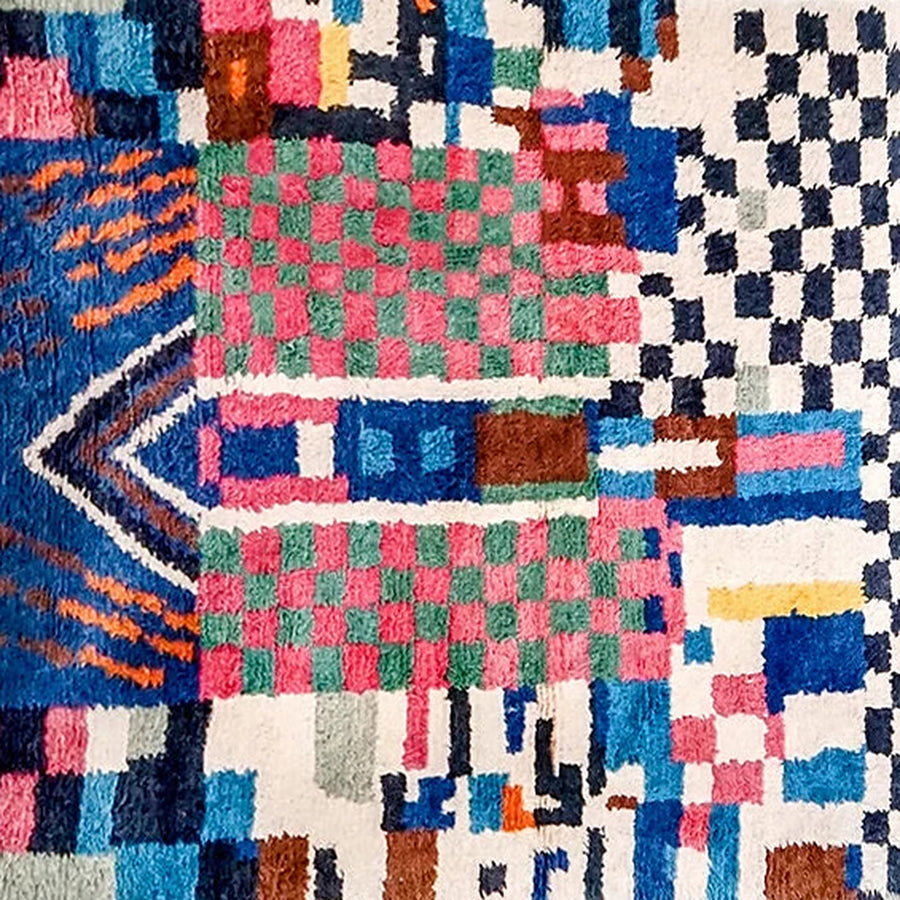 Gros plan sur le velours du tapis berbère coloré tifsa, écru et damier coloré