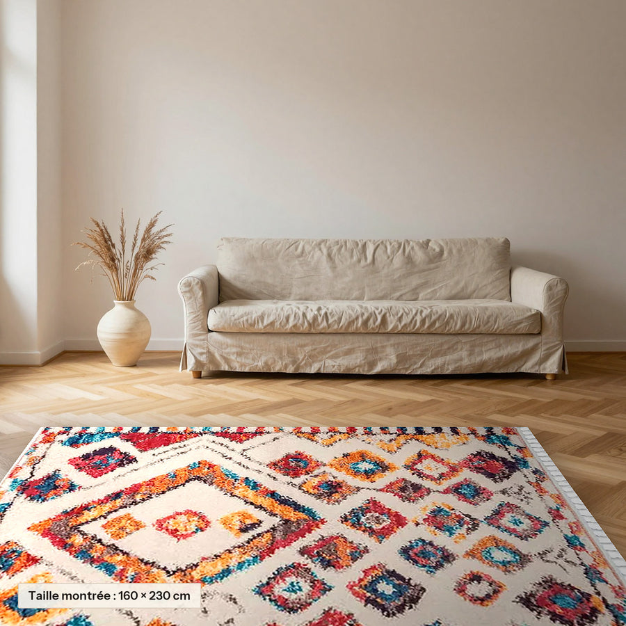 Tapis berbère coloré Tinhinan, écru à losanges vifs posé dans un salon, taille 160 × 230 cm