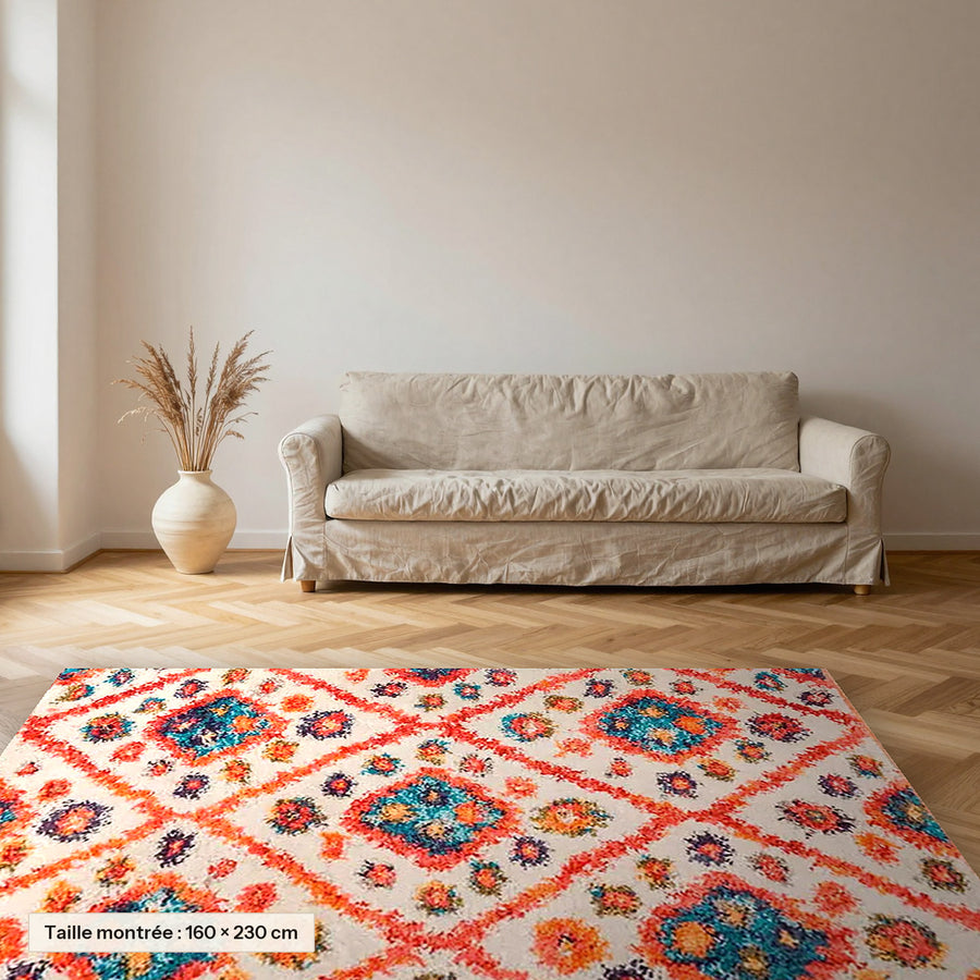 Tapis berbère coloré Anya, orange et turquoise posé dans un salon, taille 160 × 230 cm