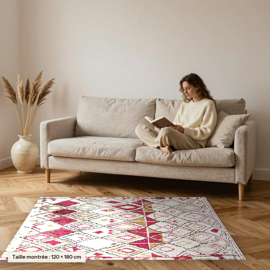 Tapis berbère coloré Arinas, écru et framboise posé devant un canapé, taille 120 × 180 cm