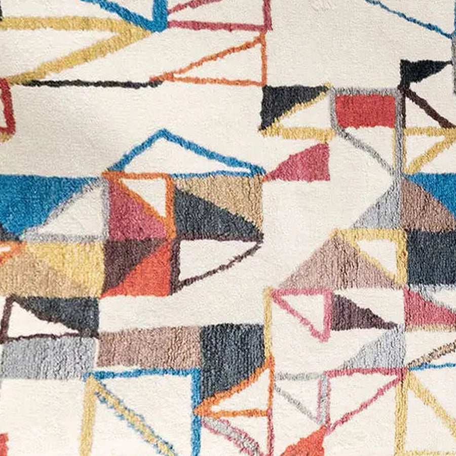 Gros plan sur le velours du tapis berbère coloré maya, écru et triangles colorés