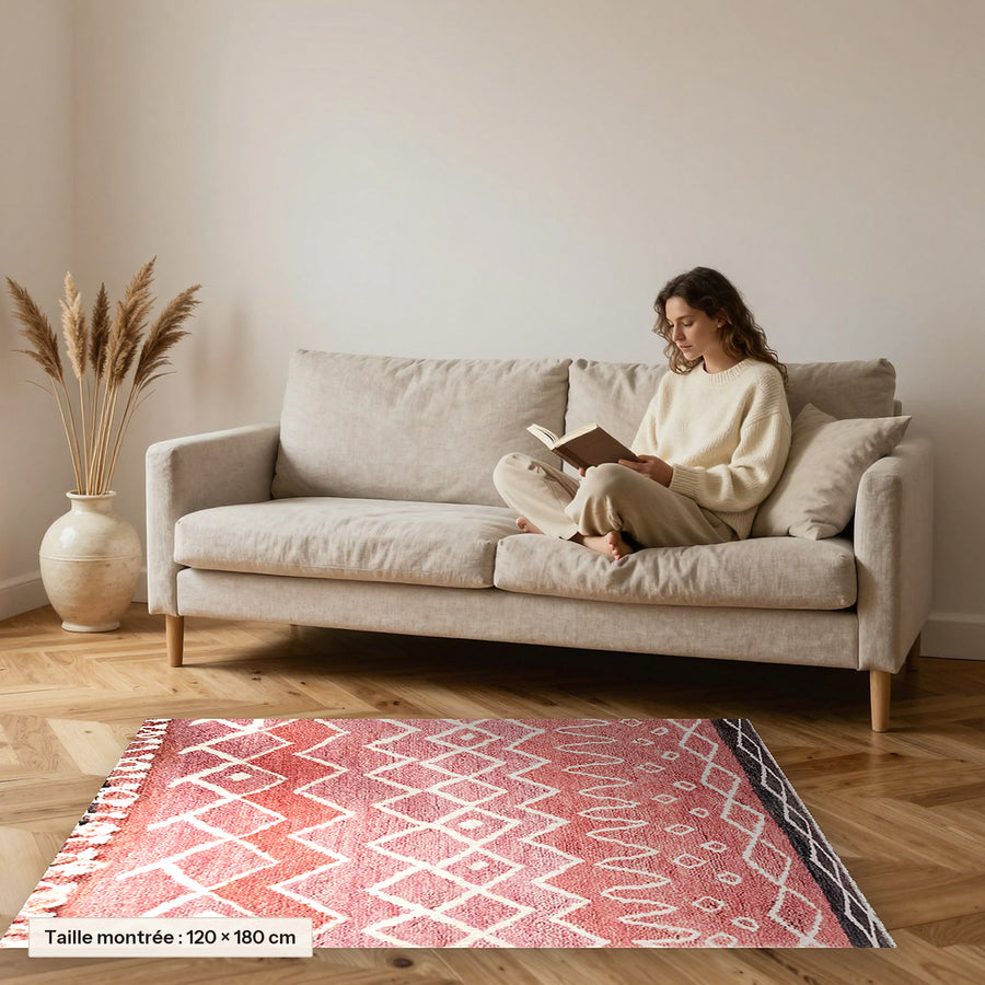 Tapis berbère coloré Itri, rose terracotta posé devant un canapé, taille 120 × 180 cm