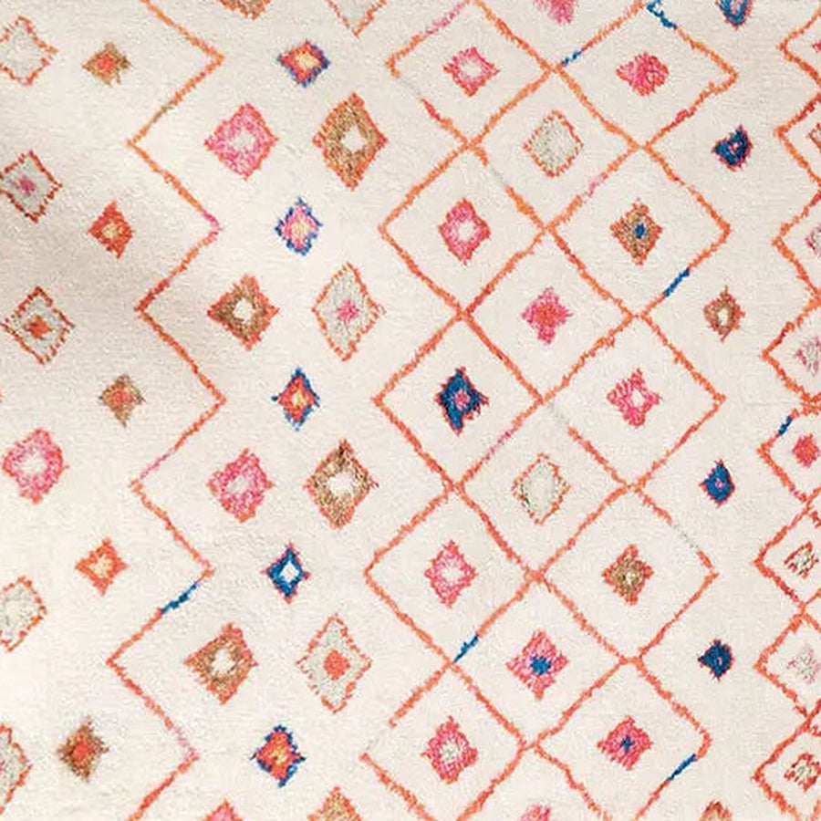Gros plan sur le velours du tapis berbère coloré amnir, écru et petits losanges