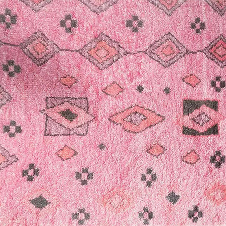 Gros plan sur le velours du tapis berbère coloré amanar, rose poudré