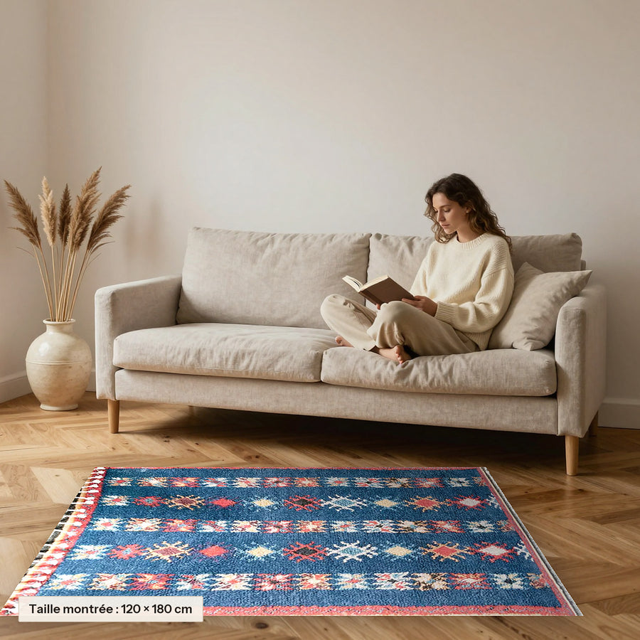 Tapis berbère coloré Ayyur, bleu rayé posé devant un canapé, taille 120 × 180 cm