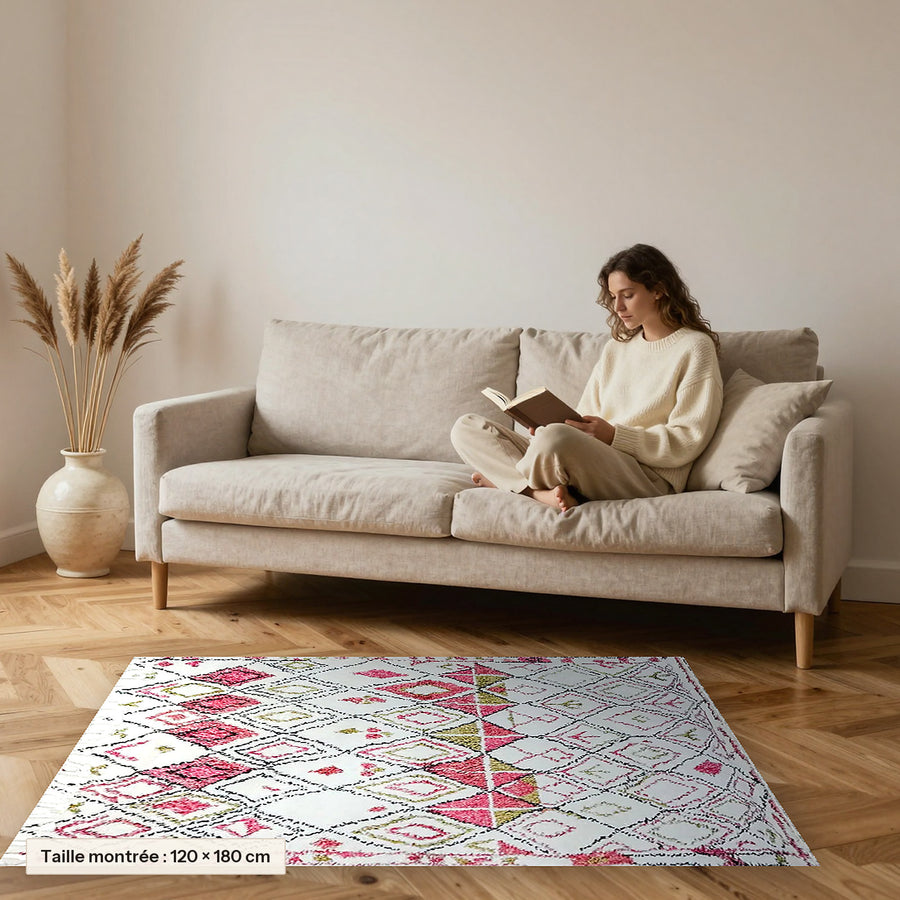 Tapis berbère coloré Amllal, écru à losanges roses posé devant un canapé, taille 120 × 180 cm
