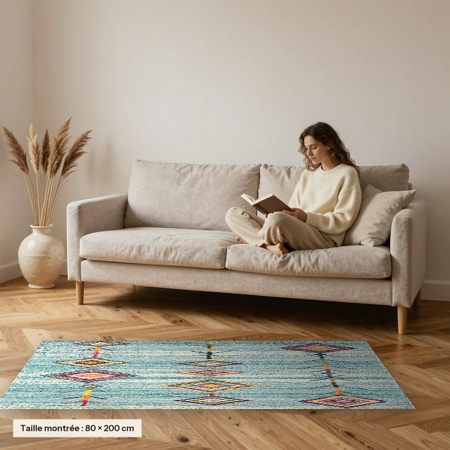 Tapis berbère coloré Masin, turquoise à losanges posé devant un canapé, taille 80 × 200 cm