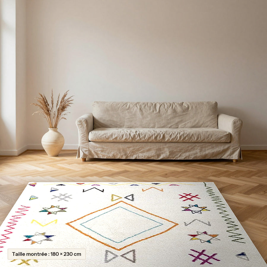Tapis berbère coloré Yani, écru à symboles tribaux posé dans un salon, taille 180 × 230 cm