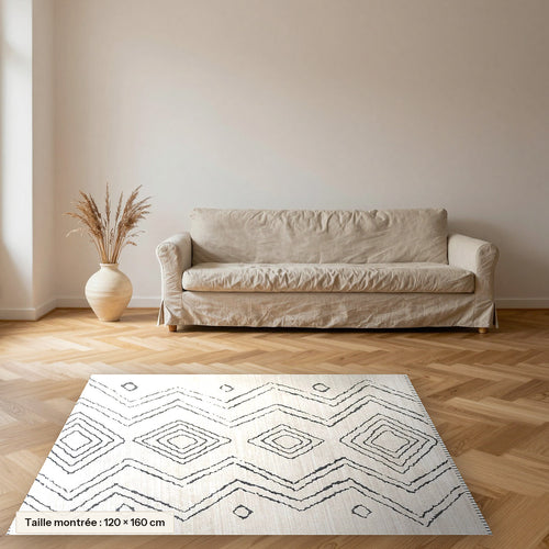Tapis Beni Ouarain Silya, écru à zigzags encre posé dans un salon, taille 120 × 160 cm